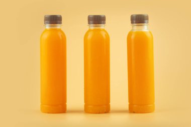 Taze portakal suyunu kahverengi kapaklı plastik bir şişeyle kapat. Yazın tazelenmek için. Sağlık için iyi bir içecek..