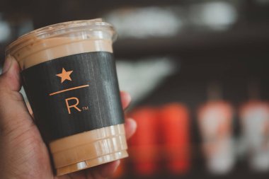 Samut Prakan, Tayland - 8 Mart 2021: Starbucks Reserve, Mega Bangnashop alışveriş merkezinde buzlu latte kahve tutan adam. Starbucks, bir Amerikan kahve şirketi ve kahve zinciri..