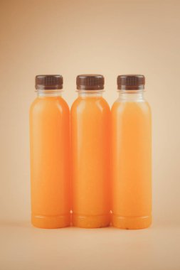 Taze portakal suyunu kahverengi kapaklı plastik bir şişeyle kapat. Yazın tazelenmek için. Sağlık için iyi bir içecek..