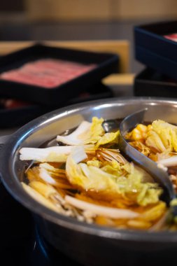 Sebze dilimleri, yüksek kalitede sığır etinden yapılmış sıcak bir çorbayla kaynatılmış. Shabu-shabu Japon yemeği.