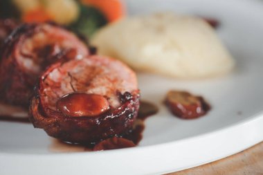 Pastırmayla sarılmış domuz filetosu. Lokantada öğle yemeği için lezzetli ve sağlıklı yemekler servis ediliyor. Seçici odak