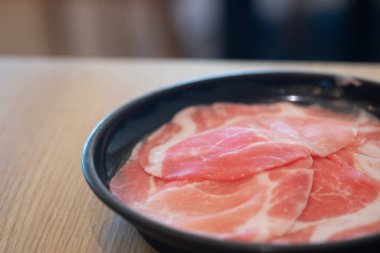 Japon güveci için siyah tabakta taze domuz eti.