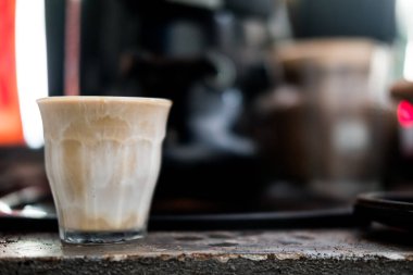 Kahve dükkanında şeffaf bardakta beyaz kremalı kahve ve espresso ile kirli kahve tarzında sıcak kahve.