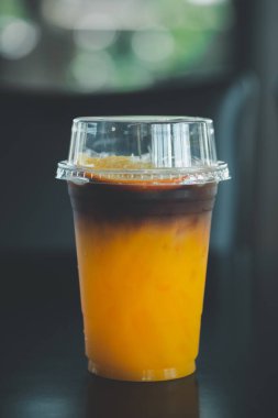 Kafedeki ahşap masaya portakal suyuyla karıştırılmış bir bardak kahve.