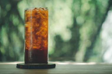 Buzlu içeceği, ahşap masadaki uzun bardakta kapat.