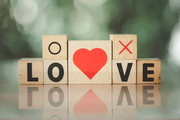 Love message written in wooden blocks with red heart shape and yes or no symbol. The concept love is not right or wrong