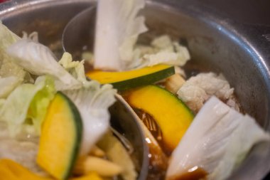 Çorbada kaynatılmış çeşitli taze sebzeler, Sukiyaki için sıcak tencere. Seçici odak.