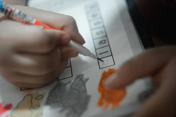 Little boy write to paper with pencil on desk. The concept of practice writing