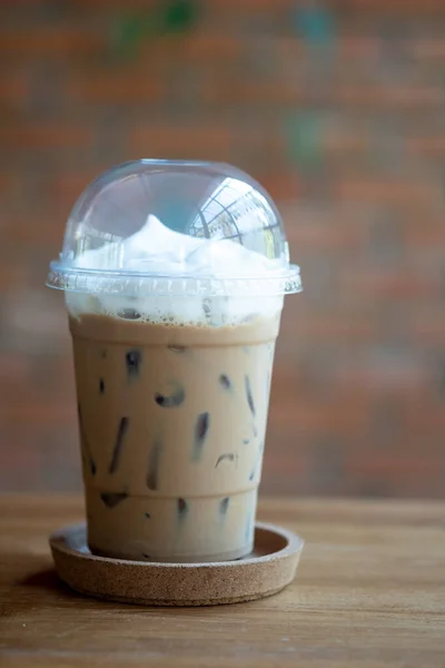 冰镇摩卡咖啡和牛奶奶油在外卖的透明塑料杯 背景是咖啡店里模糊的红砖 — 图库照片