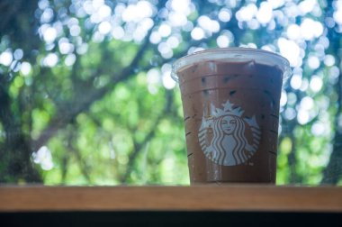 Bangkok - Tayland, 11 Nisan 2021: Masada bir fincan buzlu Starbucks kahvesi soğuk içecek, Amerika kökenli ünlü kahve markası.