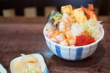 Tahta masadaki çiğ balık kasesi.