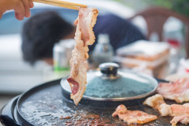 Yemek çubuklarını ev partisi için elektrikli ızgara ocağındaki pastırmayı tutmak için kullan.