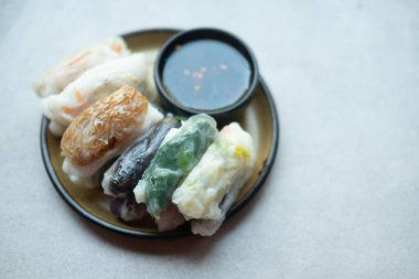 Sarımsak soğanı, taro ve bambu filizi gibi çeşitli buharda pişirilmiş hamur köftelerinin karışımı ve tatlı soslu, yemeye hazır.