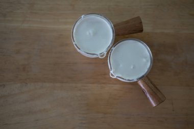 Küçük cam bardakta taze çırpılmış krema. Ahşap masada yiyecek ya da içecek için.