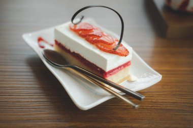 Rectangle strawberry cheesecake on white plate in cafe