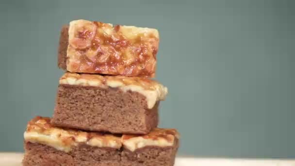 カシューナッツとトフィーケーキの正方形のスライス パンニングとスローモーションの撮影 — ストック動画