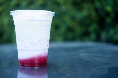 Plastik bardakta çilekli taze süt. Seçici odak
