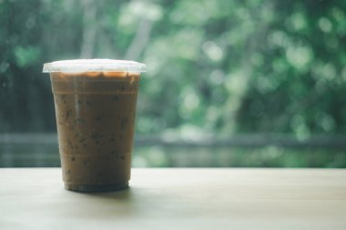 Soğuk Mocha kahvesi, ahşap masada buzlu seçici odak noktası ve kopyalama alanı.