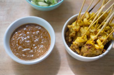 Pork satay yanında fıstık sosu ya da tatlı ve ekşi sos ile servis edilir. Tayland yemeği.