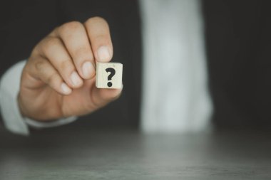 İş adamı tahta küpte soru işareti gösteriyor. İletişim ve beyin fırtınası kavramları