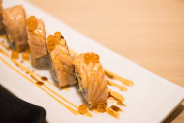 Aburi somon rulosu shushi beyaz Japon tabağında. Japonların en sevdiği uluslararası gıda konsepti