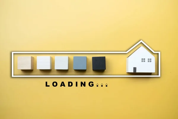 Stylized loading bar by wood block to wooden home on a yellow background
