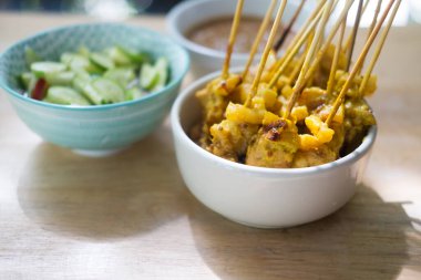 Izgara domuz eti. Taylandlı adı: moo satay, fasulye sosu, salatalık turşusu ve sirke ve soğanla servis edilir.