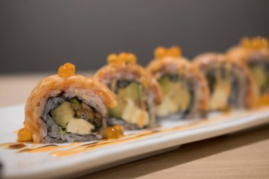 Somon suşi dürümünün yakın çekimi. Geçmişi bulanık Japon yemek stili..