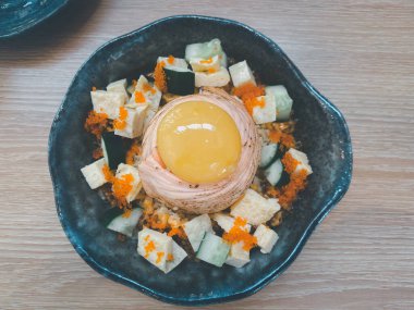 Somon balığı, saşimi, somon yumurtası ve ahşap masanın üstünde çiğ yumurta.