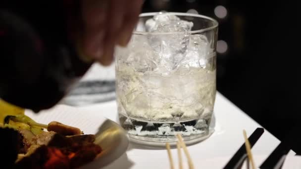 Whisky Aus Der Flasche Eiswürfel Gießen Und Soda Und Wasser — Stockvideo