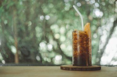 Buzlu meşrubat ve doğal arka planda bir dilim portakal.