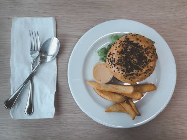 Patates kızartmasıyla servis edilen hamburgerli susam. Üst görünüm