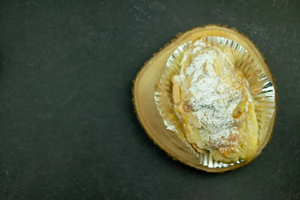 杏仁羊角面包 杏仁片和铝箔杯中的糖粉放在木制切碎板上 — 图库照片