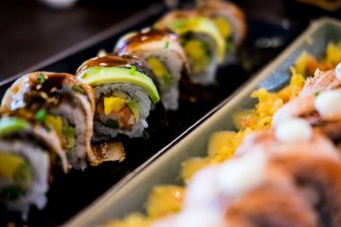 Suşi, kremalı, susamlı ve unagi soslu avokado sarıyor. Suşi menüsü. Japon yemeği..