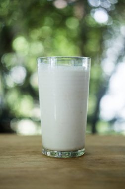 Tahta masadaki cam bardakta taze süt, doğaya aykırı.