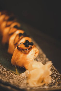 Bir tabak ızgara somon rulosu foie gras, üstünde siyah havyar ve tatlı sos, geleneksel Japon yemeği..
