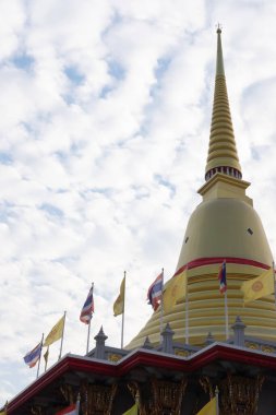Mavi gökyüzü ve beyaz bulut arkaplanından görünen altın bir pagoda.