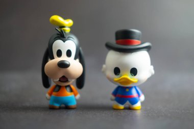 Samut Prakan, Tayland - 24 Mayıs 2021: Şirin heykelcik Goofy ve Scrooge McDuck, Miniso mağazasındaki kör kutuda oyuncak fare aile figürü