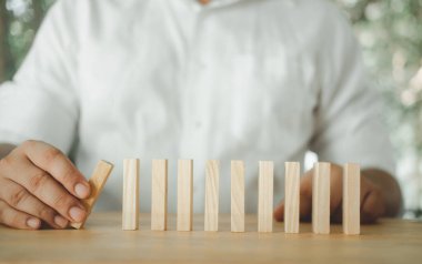 Kırpılmış insan görüntüsü tahta blokları sırayla düşürüyor. Yönetim ve strateji planı, büyüme işi başarı süreci ve ekip kavramı