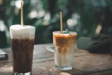 Seçici olarak buzlu latte kahveye ve ahşap masada buzlu mocha 'ya odaklan. Yaz soğuk içecek konsepti