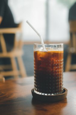 Kafe 'deki ahşap masaya yerleştirilmiş tatlı balla karıştırılmış buzlu portakal espresso.