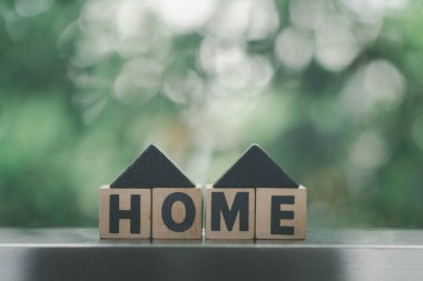 Yuva kelimesiyle ahşap küp bloğu ve UP ok sembolü. Emlak işi eğilimleri kavramı.