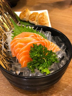 Japon restoranında buzda servis edilen taze çiğ somon sashimi. Taze çiğ somon balığı sashimi Japon mutfağında dilimlenir. Taze somon balığı ve Japon yemeği konsepti..
