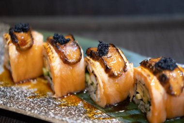Bir tabak ızgara somon rulosu foie gras, üstünde siyah havyar ve tatlı sos, geleneksel Japon yemeği..