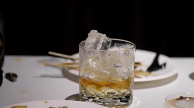 Adam partide buzlu soda ve suyla birlikte bir bardak viski al.