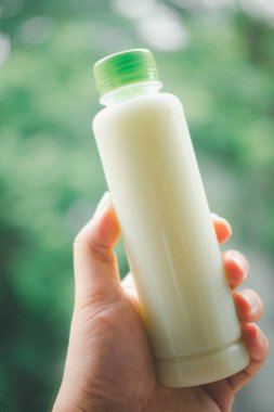 Soğutulmuş guava suyu şişeleri insan elinin üzerinde. Kapat.