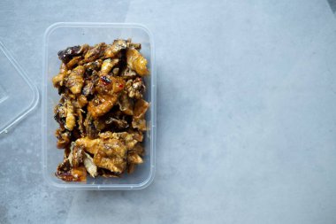 Tayland baharatlı kalamar atıştırmalığı, acı biber soslu kızarmış kalamar plastik kutuda, atıştırmalık ya da çöl olarak ye..