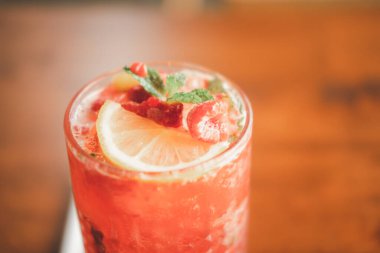 Taze ahududu süslemeli, dilimlenmiş limon ve nane aromalı meyve kokteyli. Seçici odak