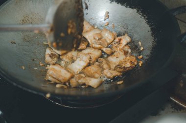 Sıcak tavada sarımsak ve biberli domuz eti pişirmek, ev yapımı yemekler.