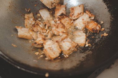 Dökme demir bir tavada sarımsaklı domuz eti pişirmek. Ev yapımı yemek. Kapat.